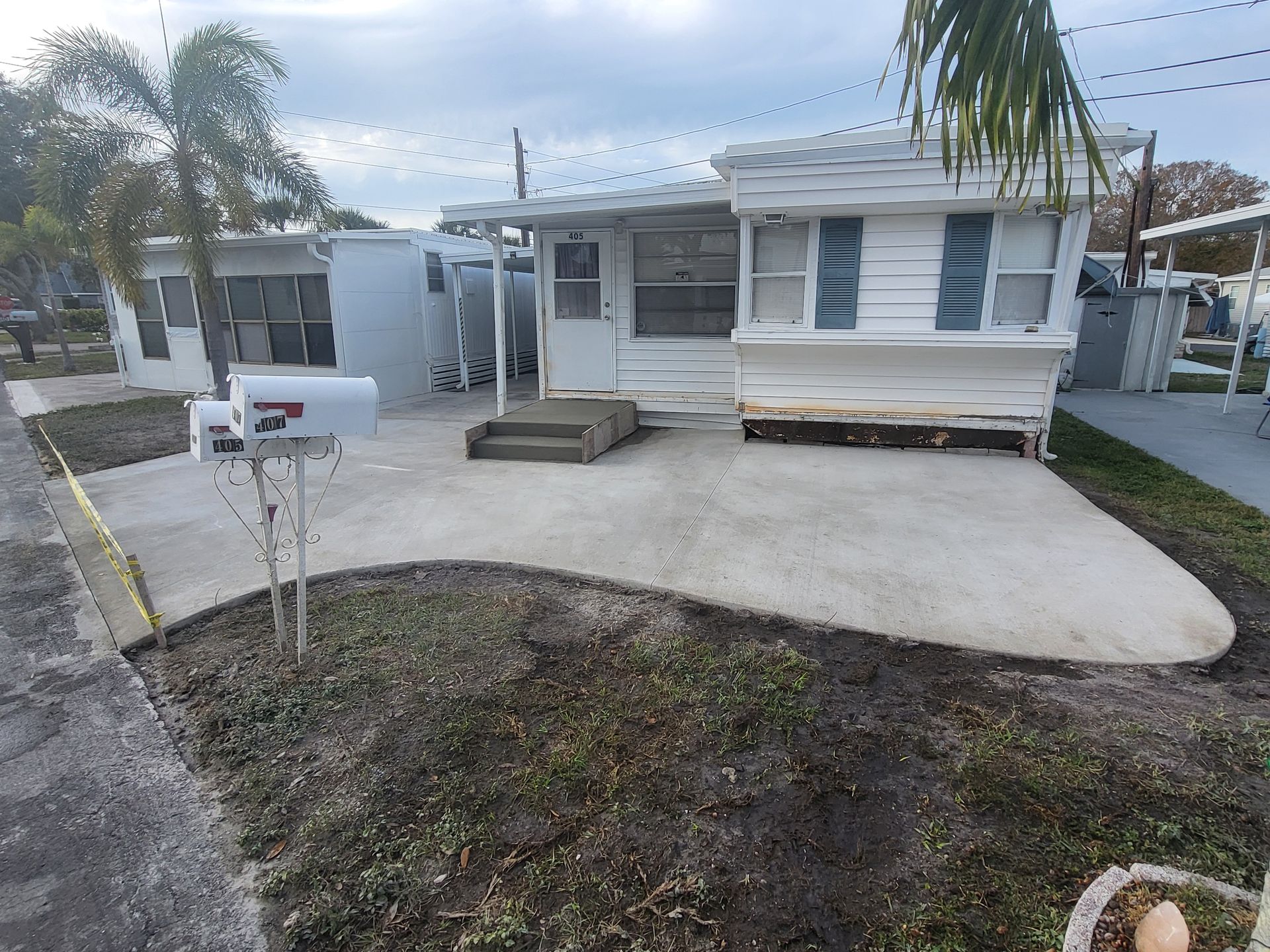 A mobile home with a mailbox in front of it.
