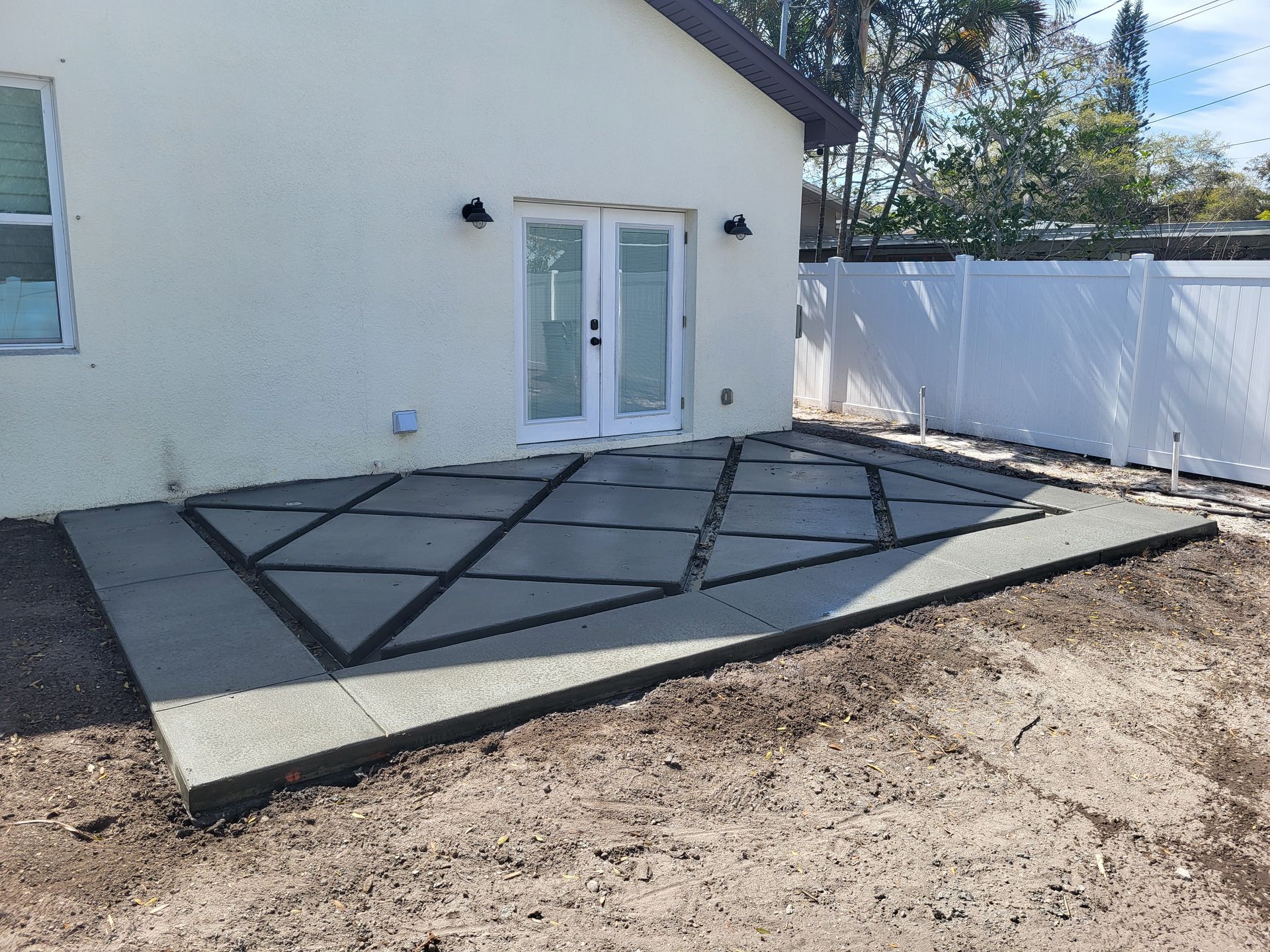 A patio is being built in the backyard of a house.