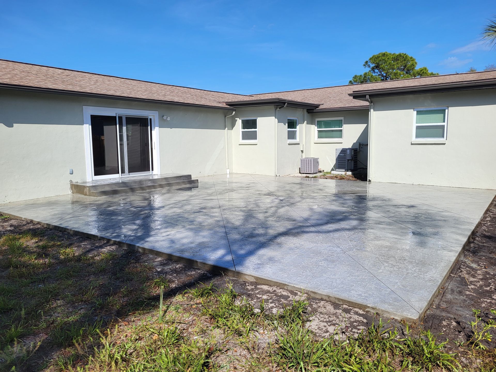 A white house with a concrete patio in front of it.