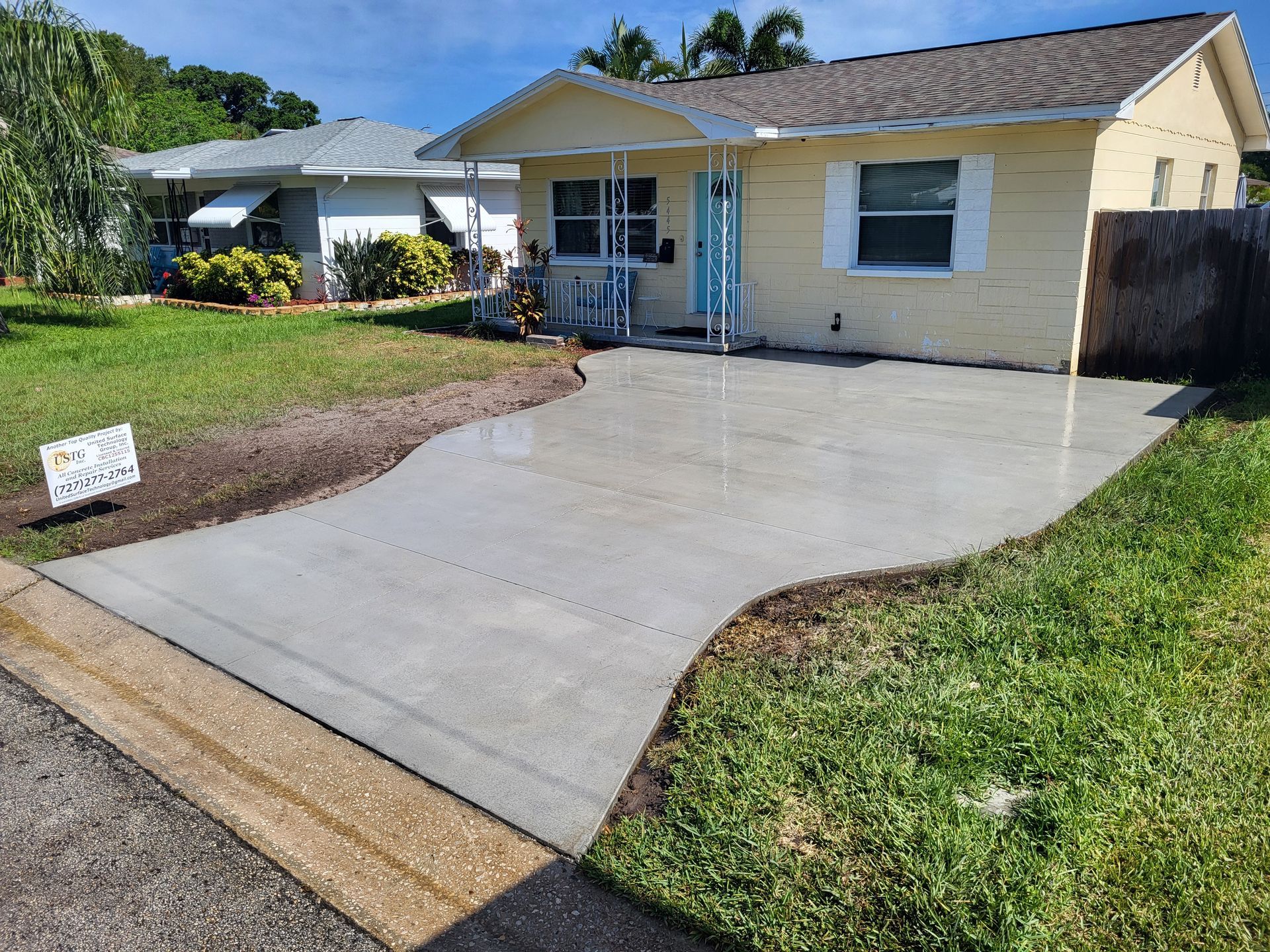 A house with a concrete driveway in front of it.