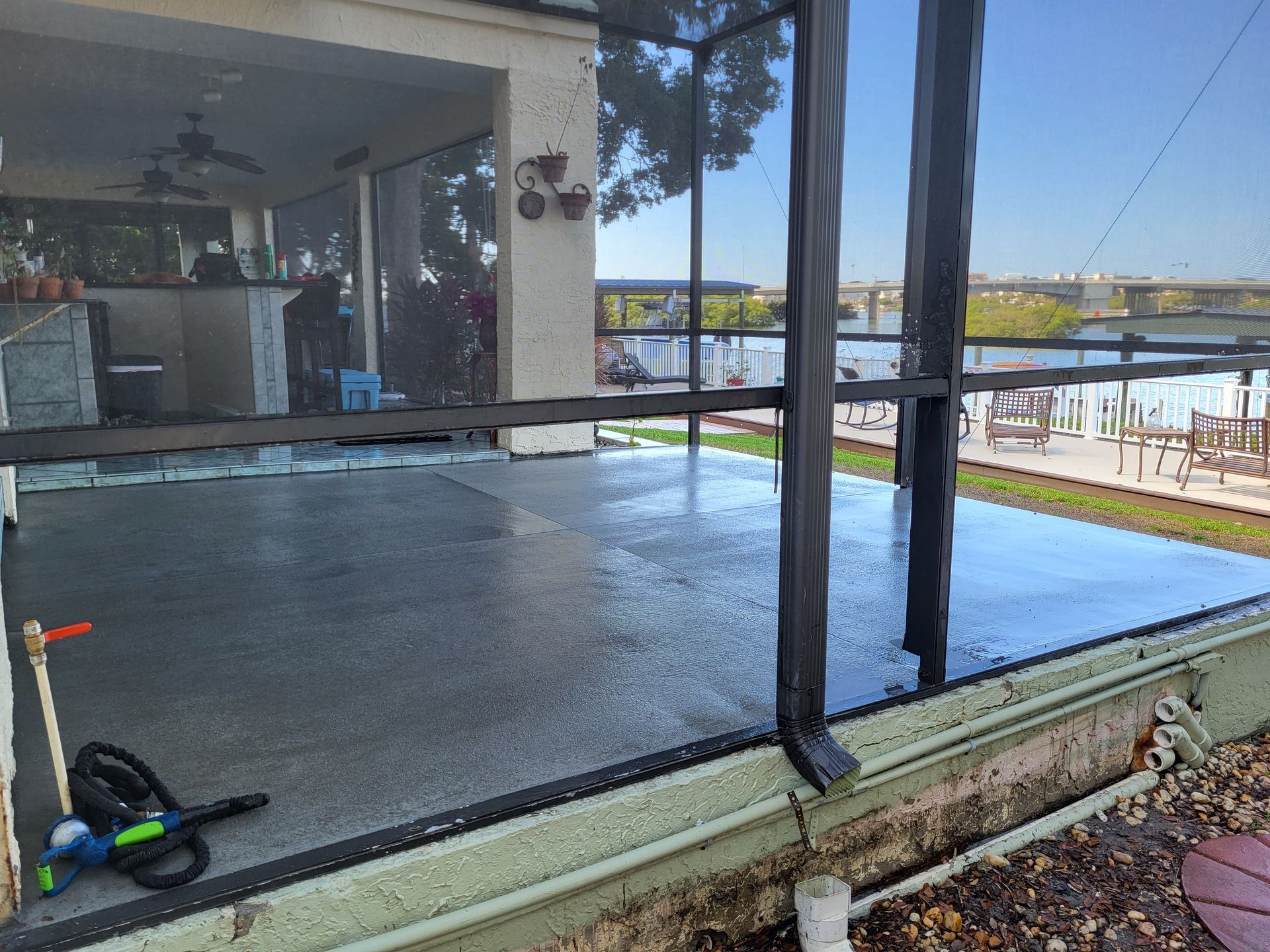 A screened in porch with a view of a lake.