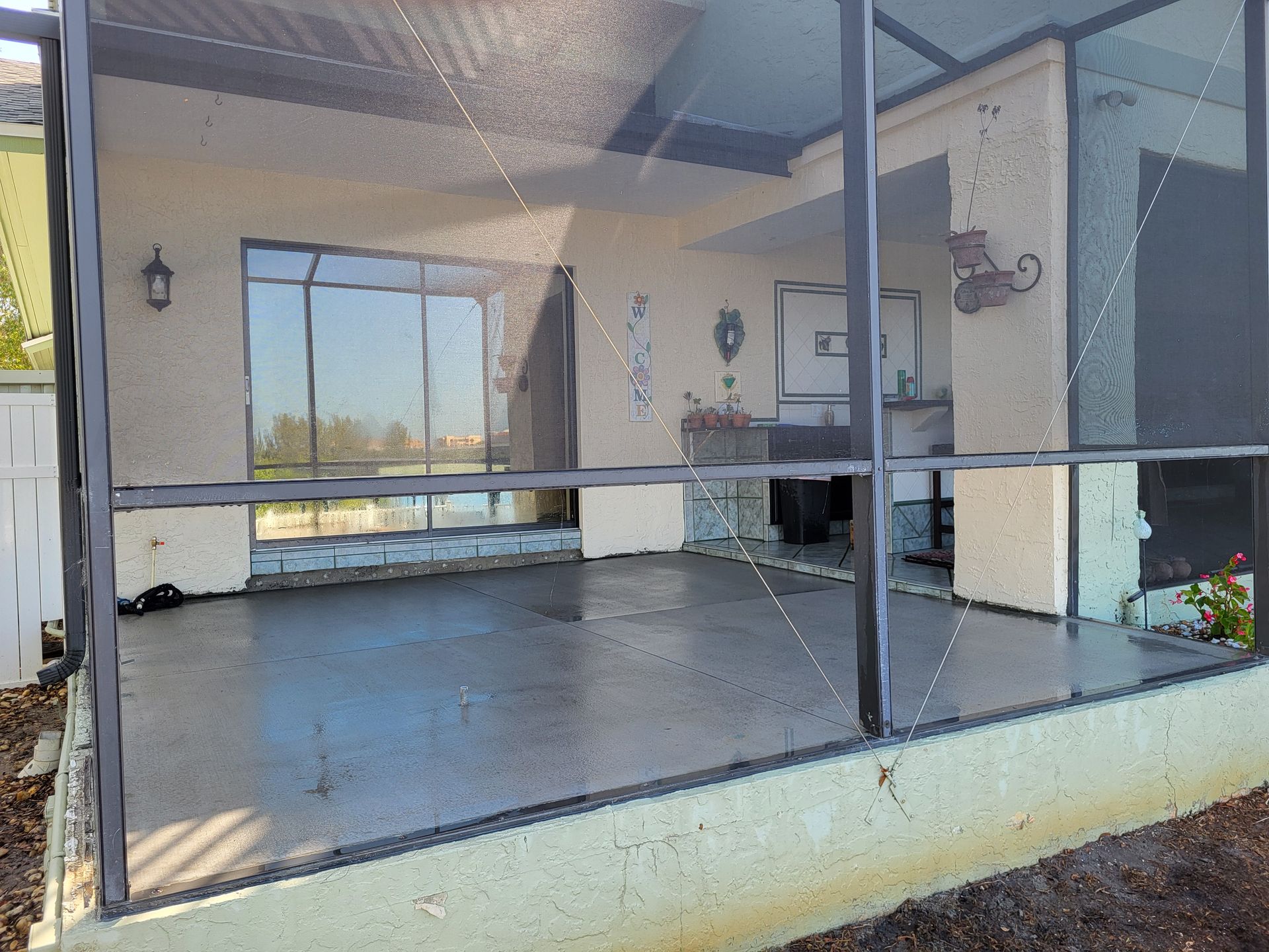 A screened in porch with a lot of windows and a cat on it.