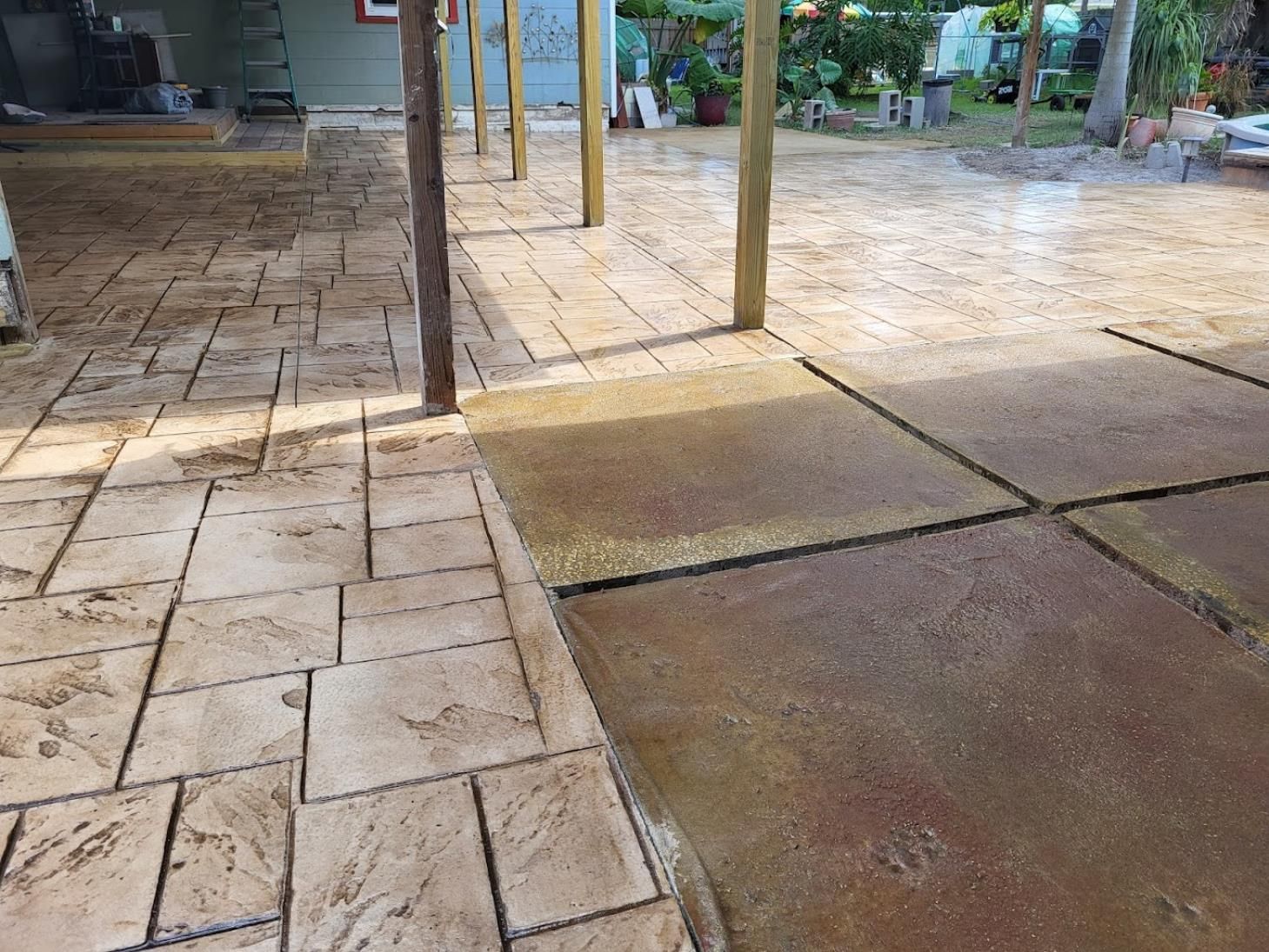 A patio with a wooden roof and a concrete floor.