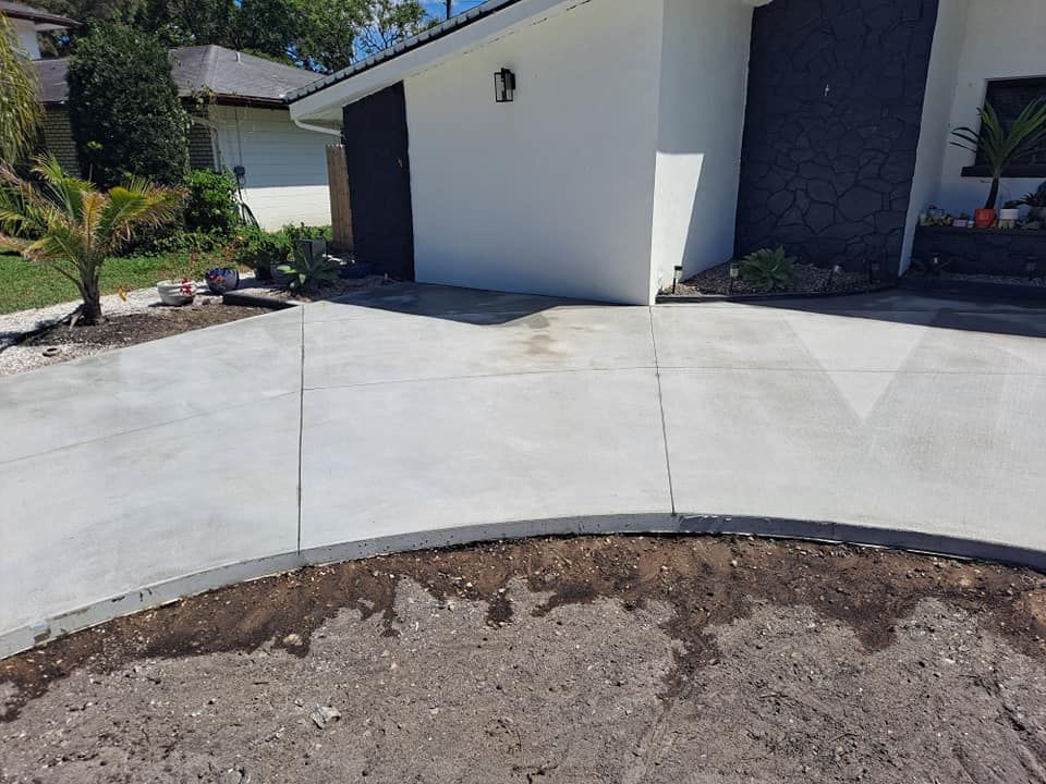 A concrete driveway is being built in front of a house.