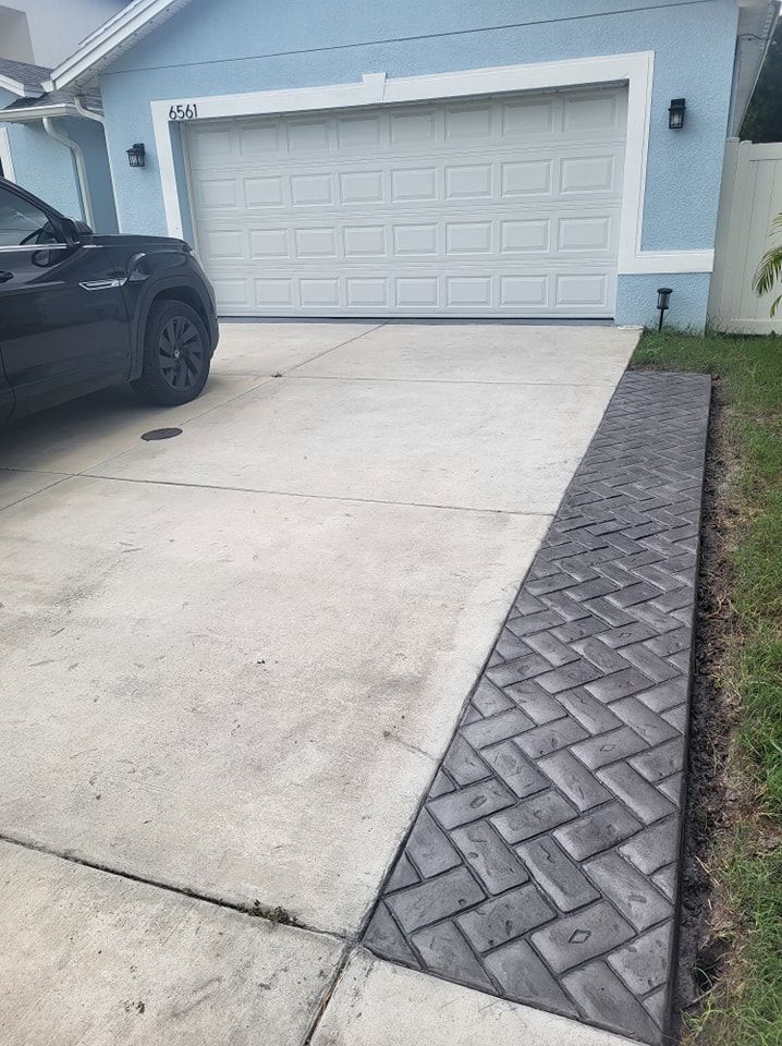 A car is parked in a driveway next to a garage door.