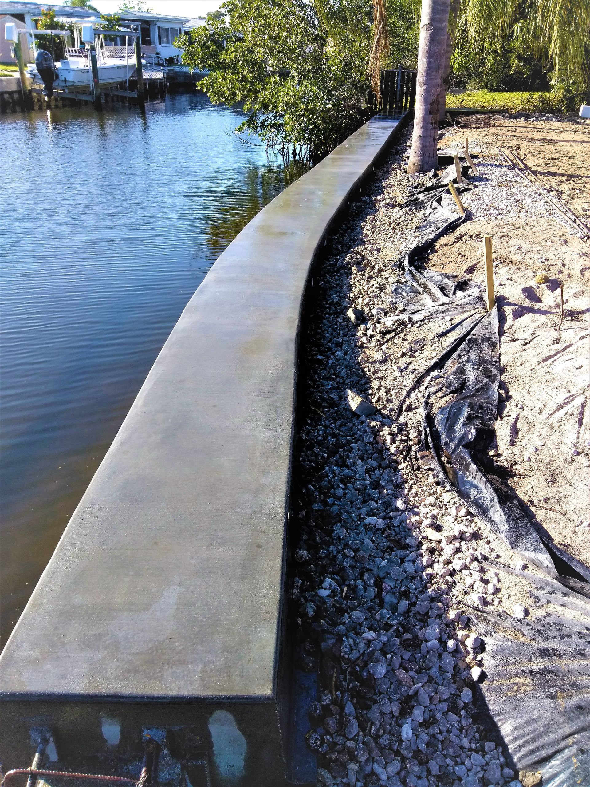 A concrete wall is being built next to a body of water