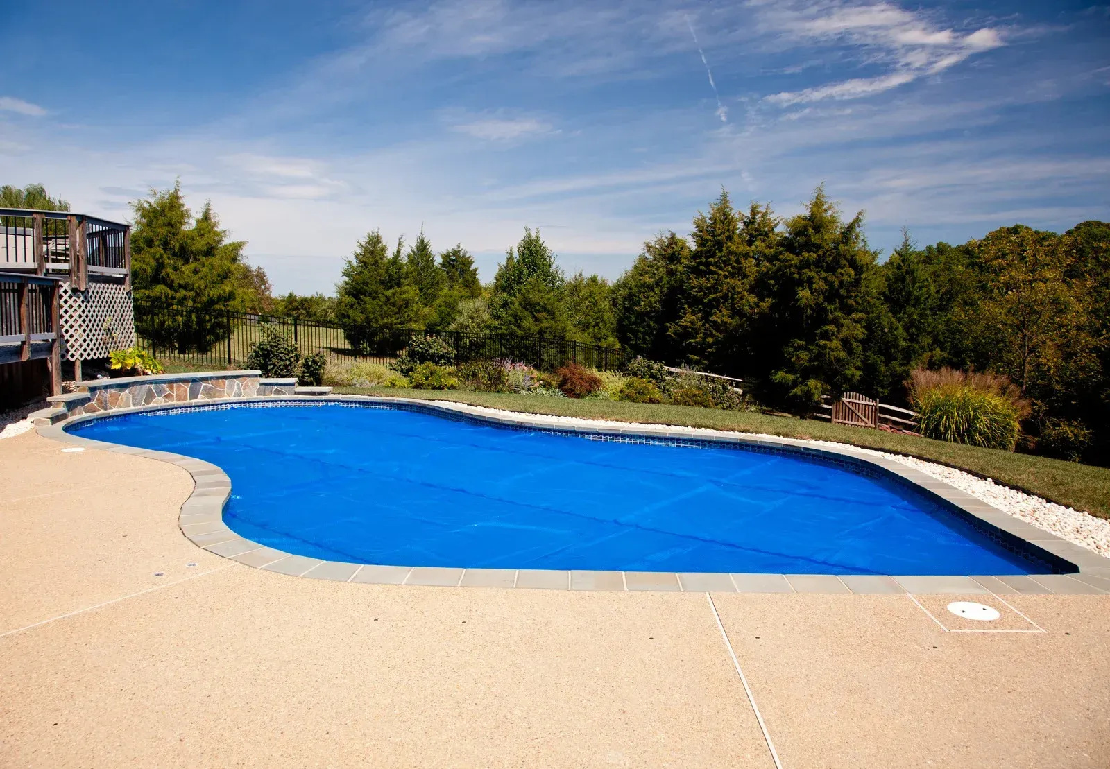 A large swimming pool with a blue cover on it.
