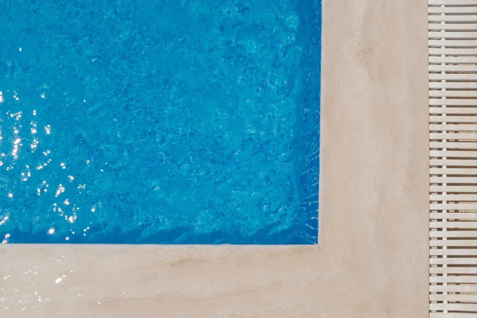 An aerial view of a swimming pool with blue water and a white border.