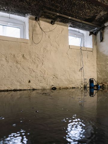 A person is laying tiles on a wooden floor.