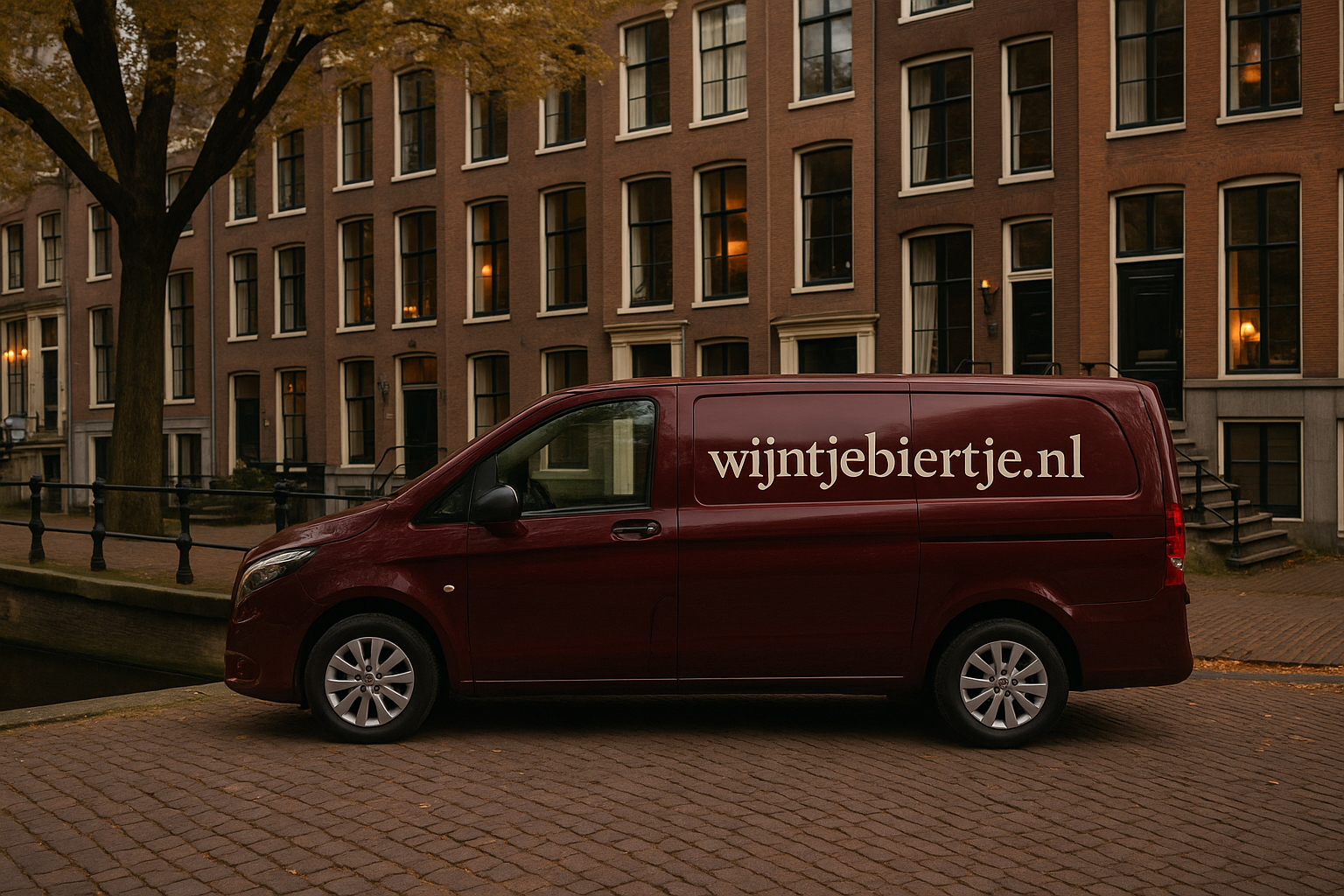 Bordeauxrode bestelbus met wijntjebiertje.nl op de zijkant, geparkeerd aan Amsterdamse gracht voor herenhuizen.