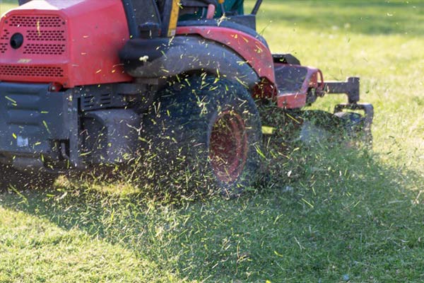 Stump Grinding — Mower Working On Grass in Asheville, NC