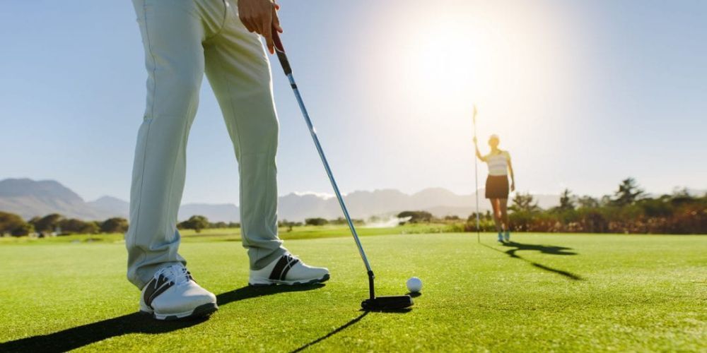 A man and a woman are playing golf on a golf course.