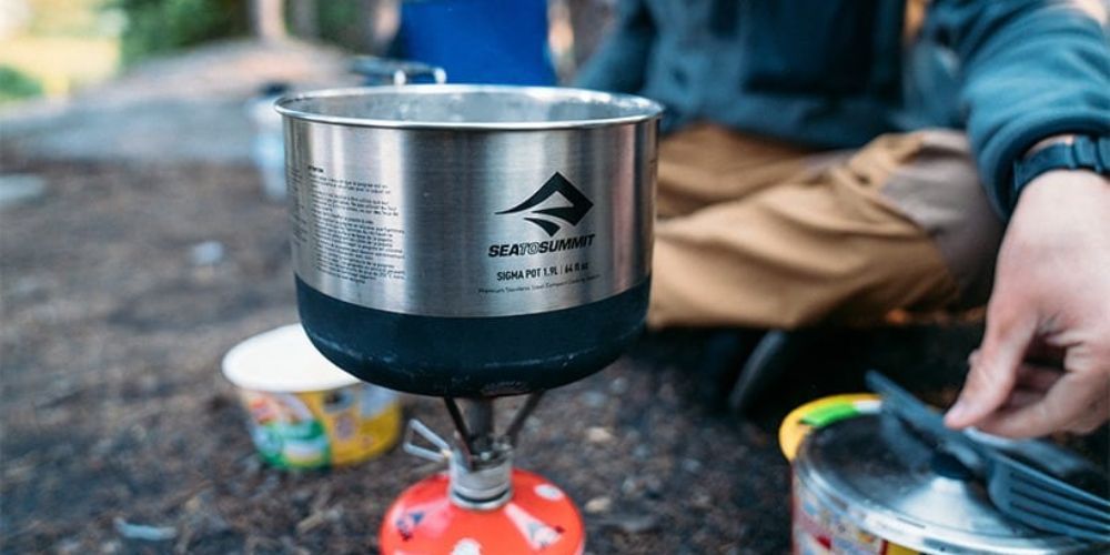 backpacker using a cook stove