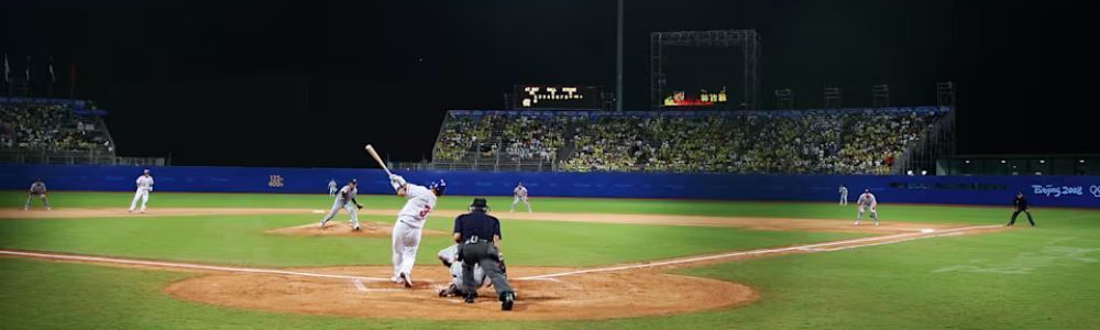 A baseball game is being played in a stadium at night.