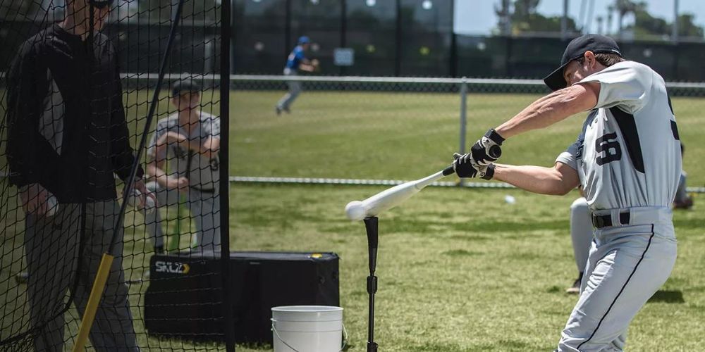 A baseball player is swinging a bat at a ball.