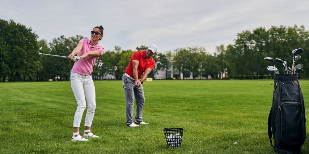 A man and a woman are playing golf on a golf course.