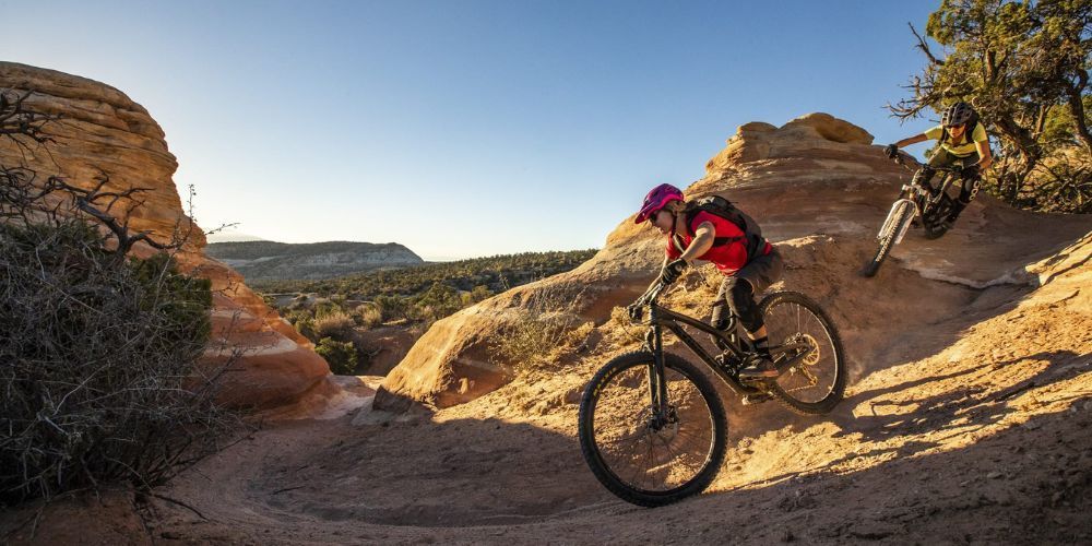 A man is riding a mountain bike down a dirt trail.