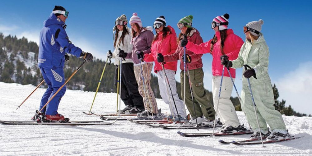 A group of people are skiing down a snow covered slope.