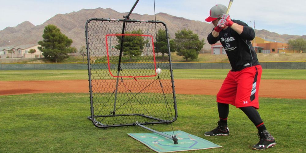 A baseball player is swinging a bat at a ball on a field.