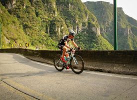 A man is riding a bike down a mountain road.