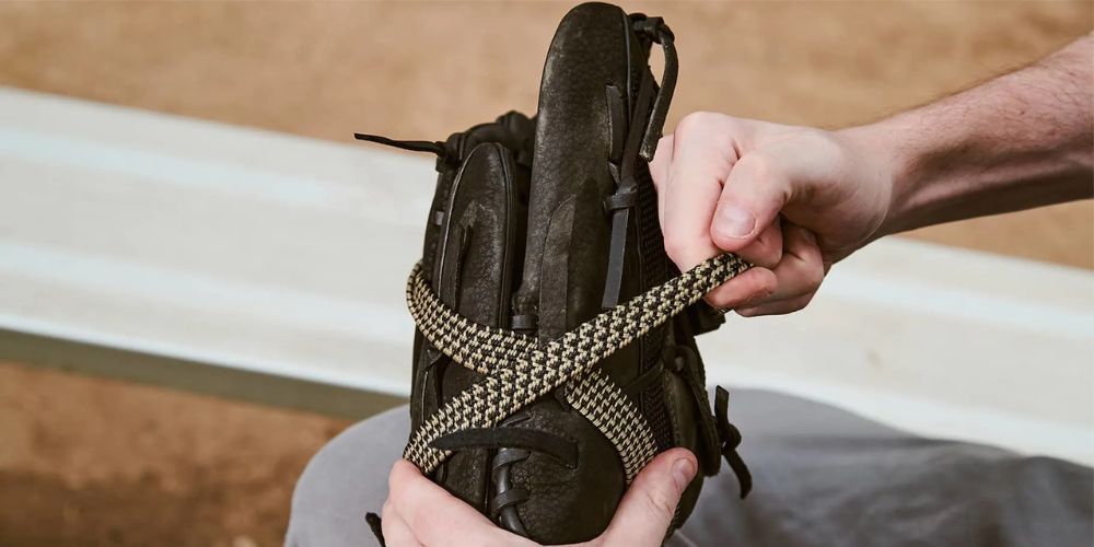 A person is tying a baseball glove with a string.