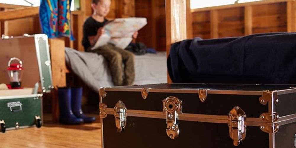 boy at camp with his camp trunk