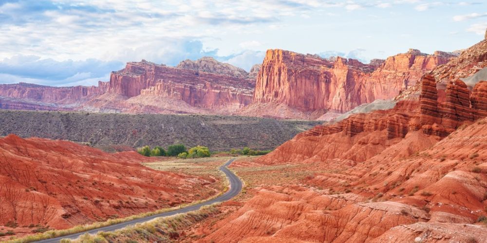 A road in the middle of a desert with mountains in the background.