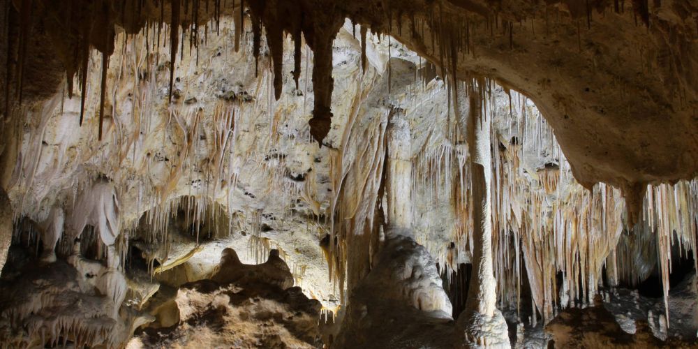 A cave with a lot of icicles hanging from the ceiling.