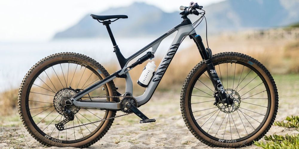 A mountain bike is parked on the side of a dirt road.