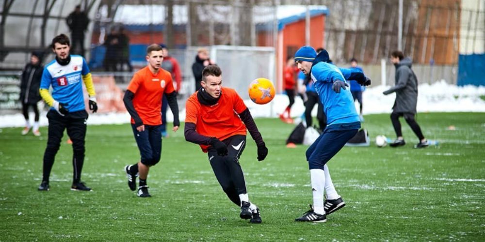 A group of young men are playing soccer on a field.