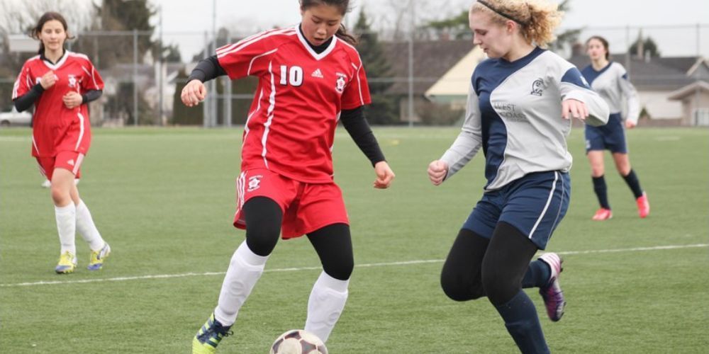 A group of women are playing soccer on a field.