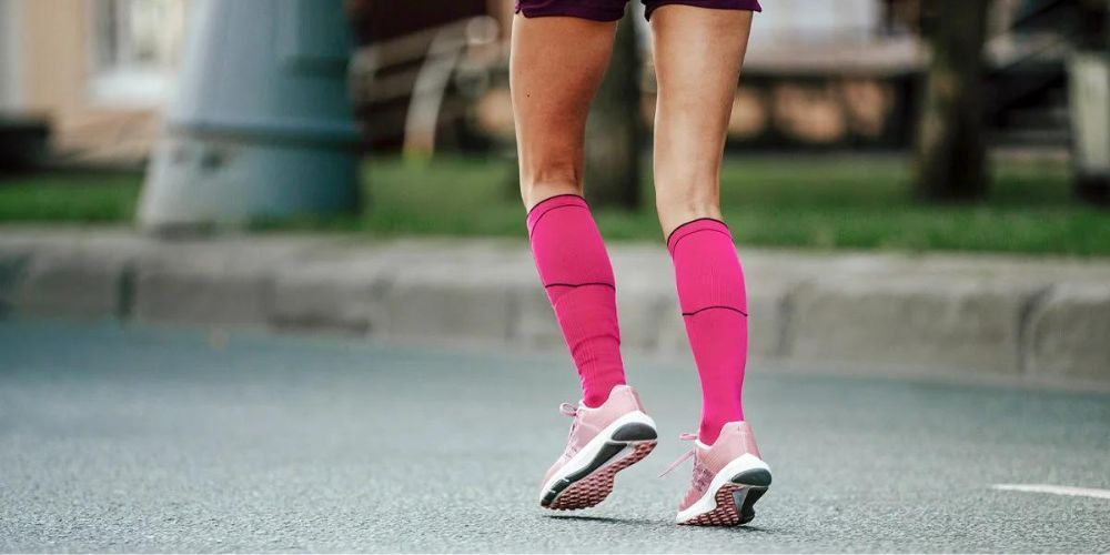 a woman runner with pink compression socks