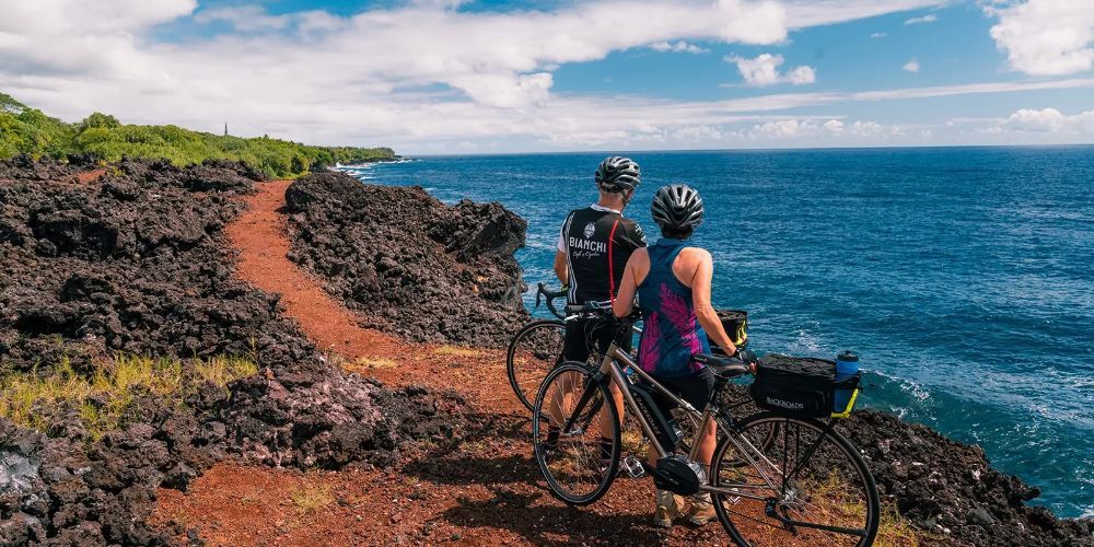 Biking on a trail with Hawaiian volcano in background