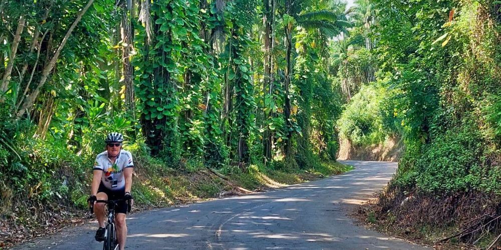 Cyclist biking along a Hawaiian coastal path