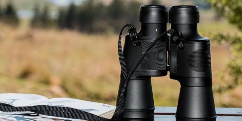 A pair of binoculars sitting on top of a wooden table.