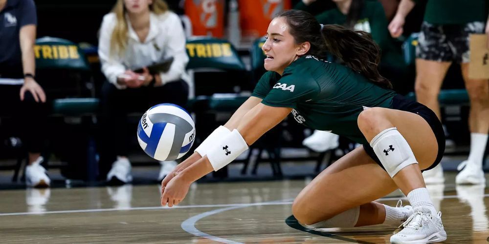 A woman is playing volleyball on a court.