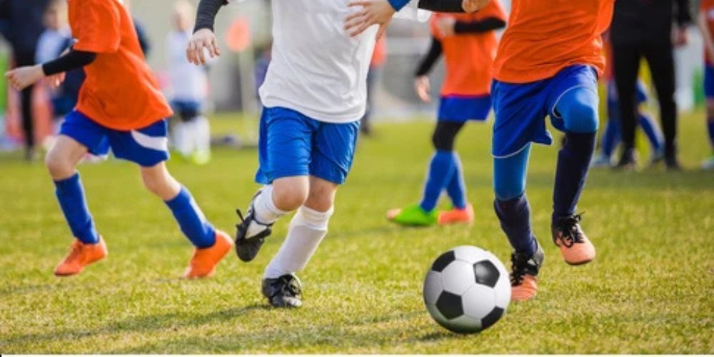 A group of young boys are playing soccer on a field.