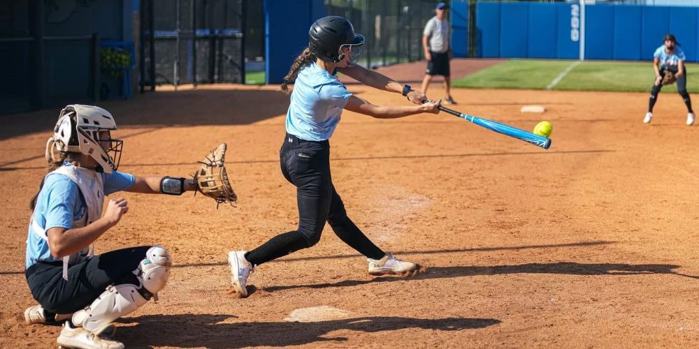 batter hitting a softball during a game