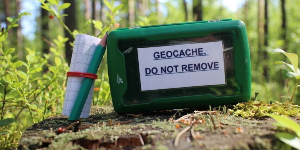 A green box with a label on it that says geocache do not remove.