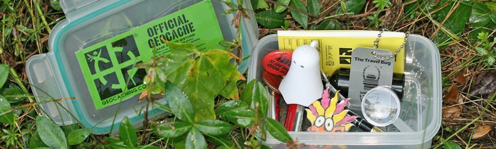 A plastic container filled with various items is sitting in the grass.