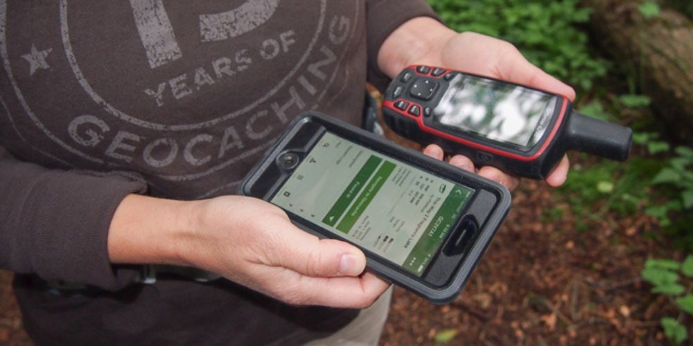 person comparing 2 geocaching gps devices