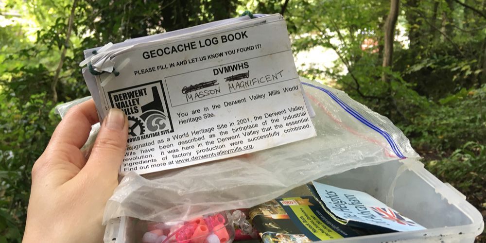 person looking at a geocache logbook