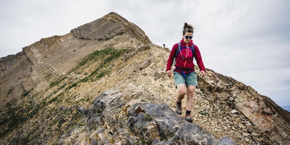 A woman is hiking up the side of a mountain.