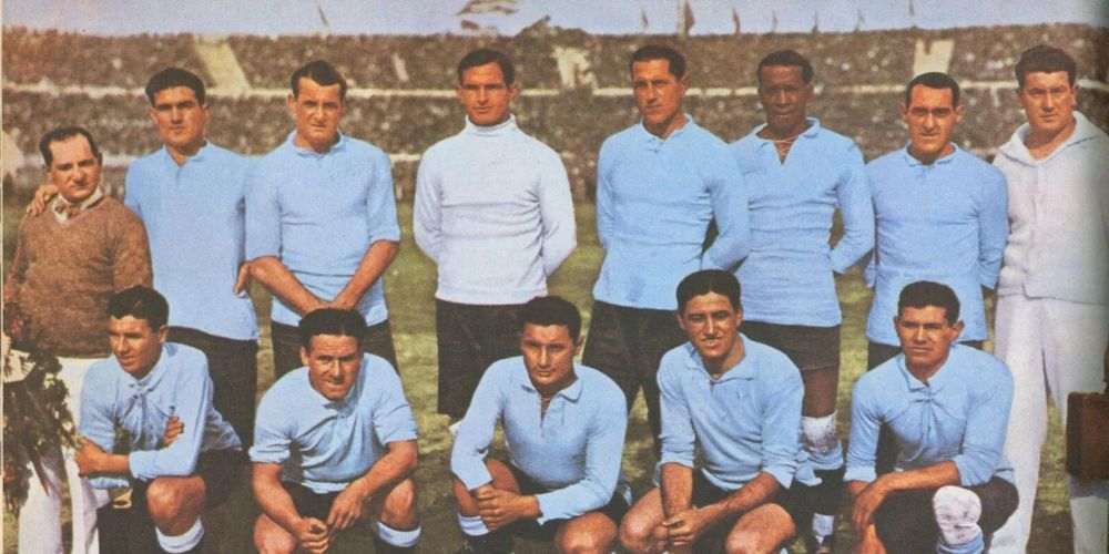 A group of men in blue shirts are posing for a picture