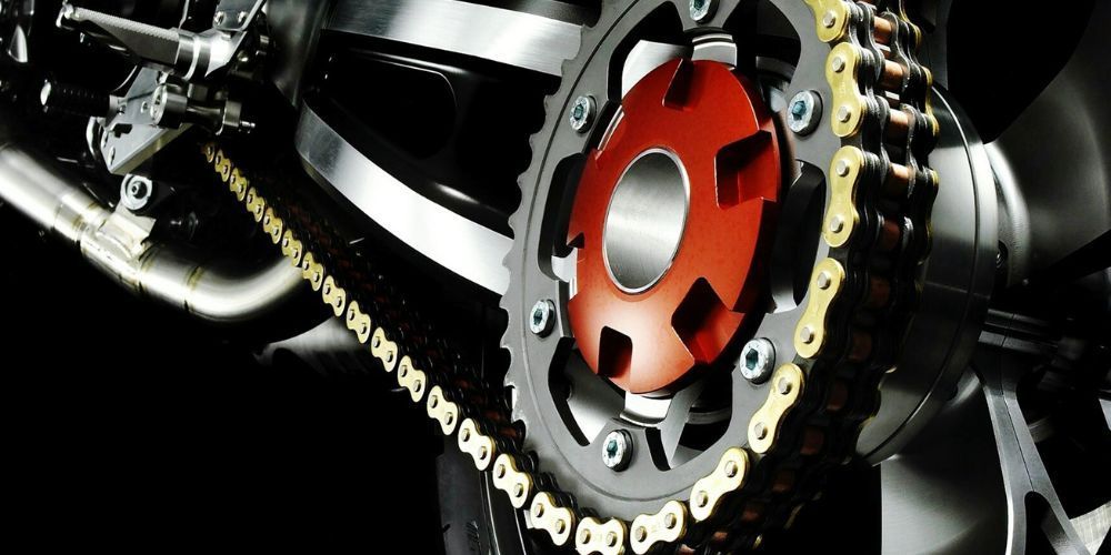 A close up of a motorcycle chain and sprocket