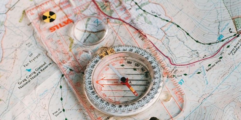 A compass is sitting on top of a map.