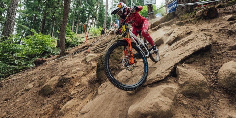 A person is riding a mountain bike down a rocky trail.