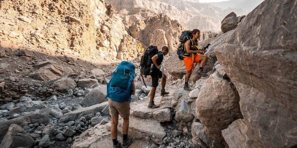 A group of people are hiking up a rocky mountain.