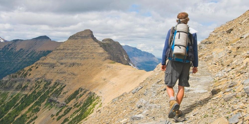 A person with a backpack is hiking up a mountain.