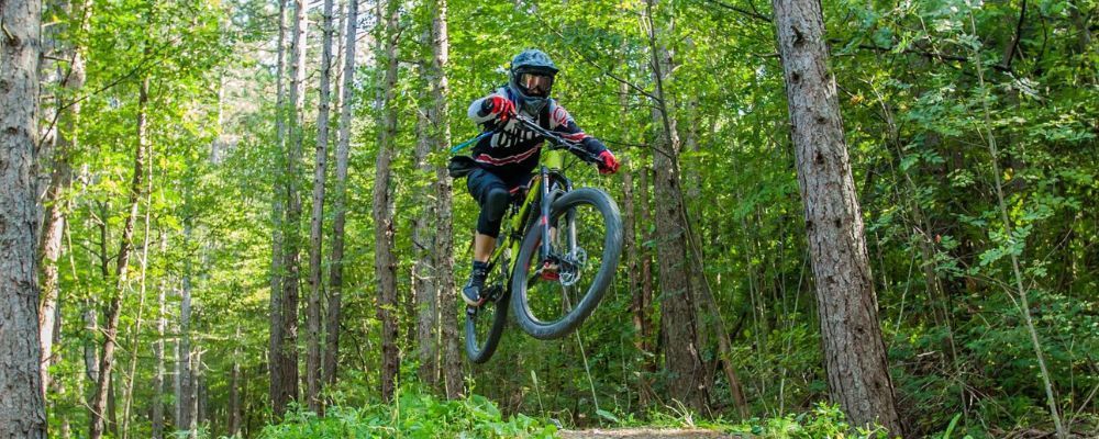 man jumping mountain bike on a trail